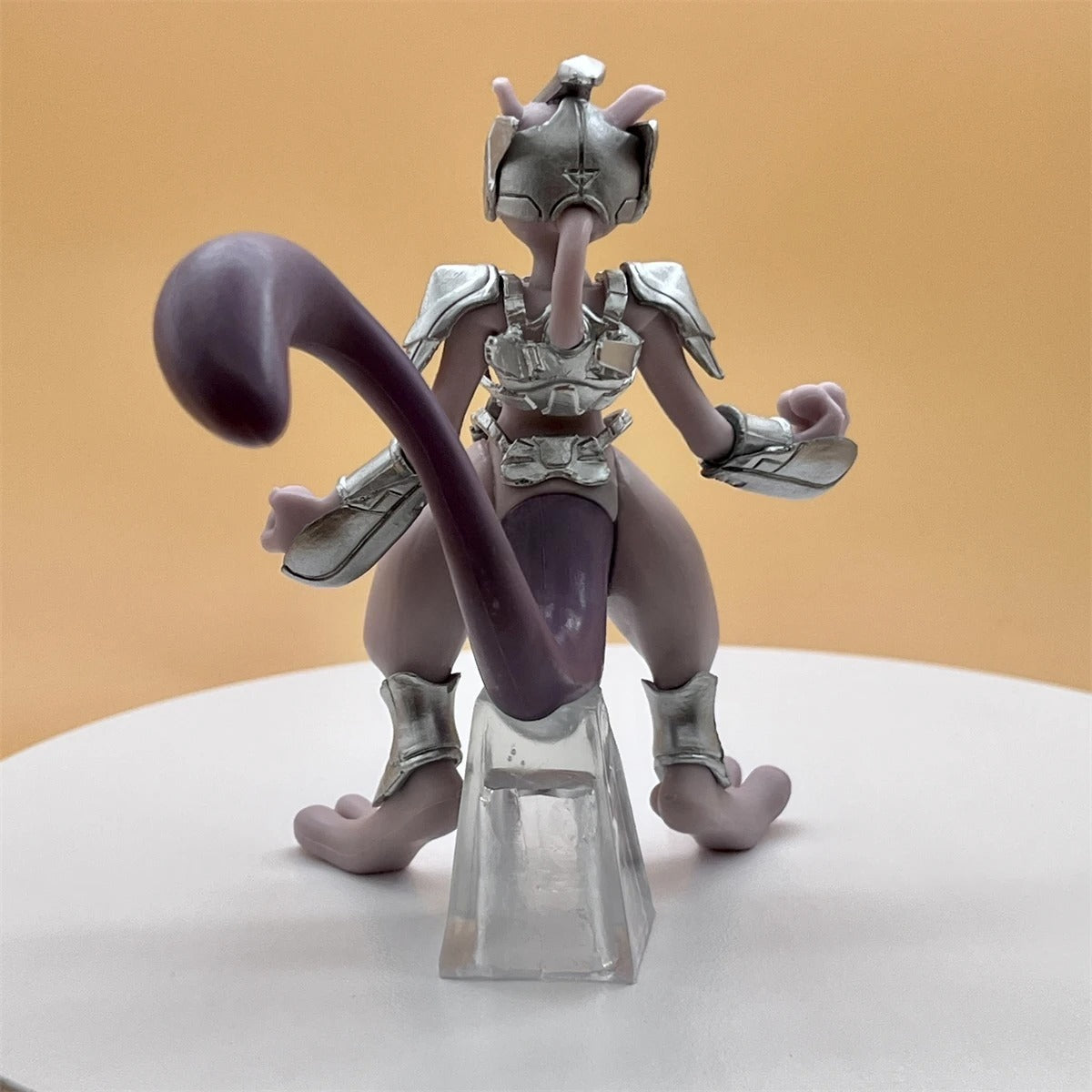Toy figure with a metallic helmet and purple tongue on a white surface with a beige background