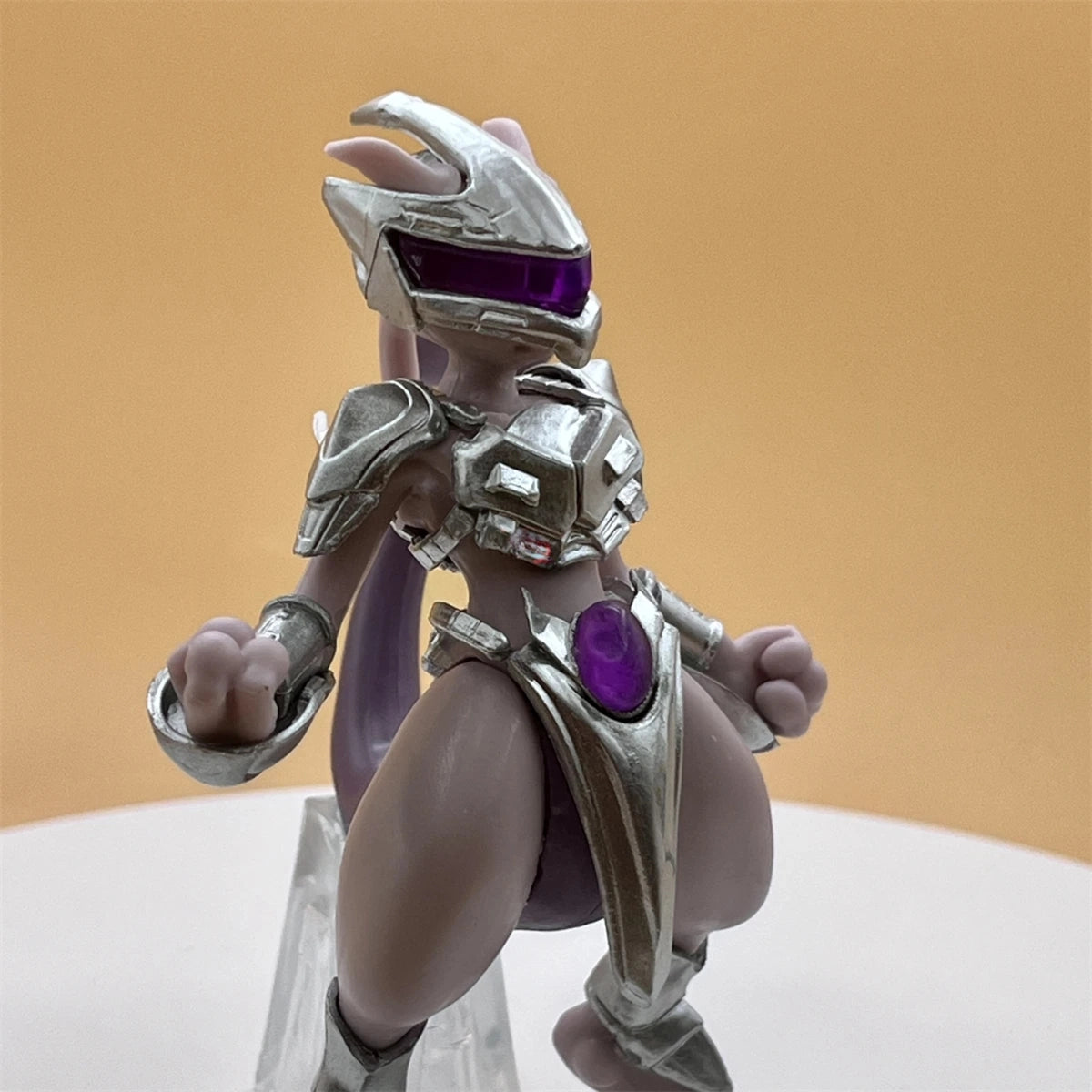 Toy figure with silver armor and purple gemstones on a beige background